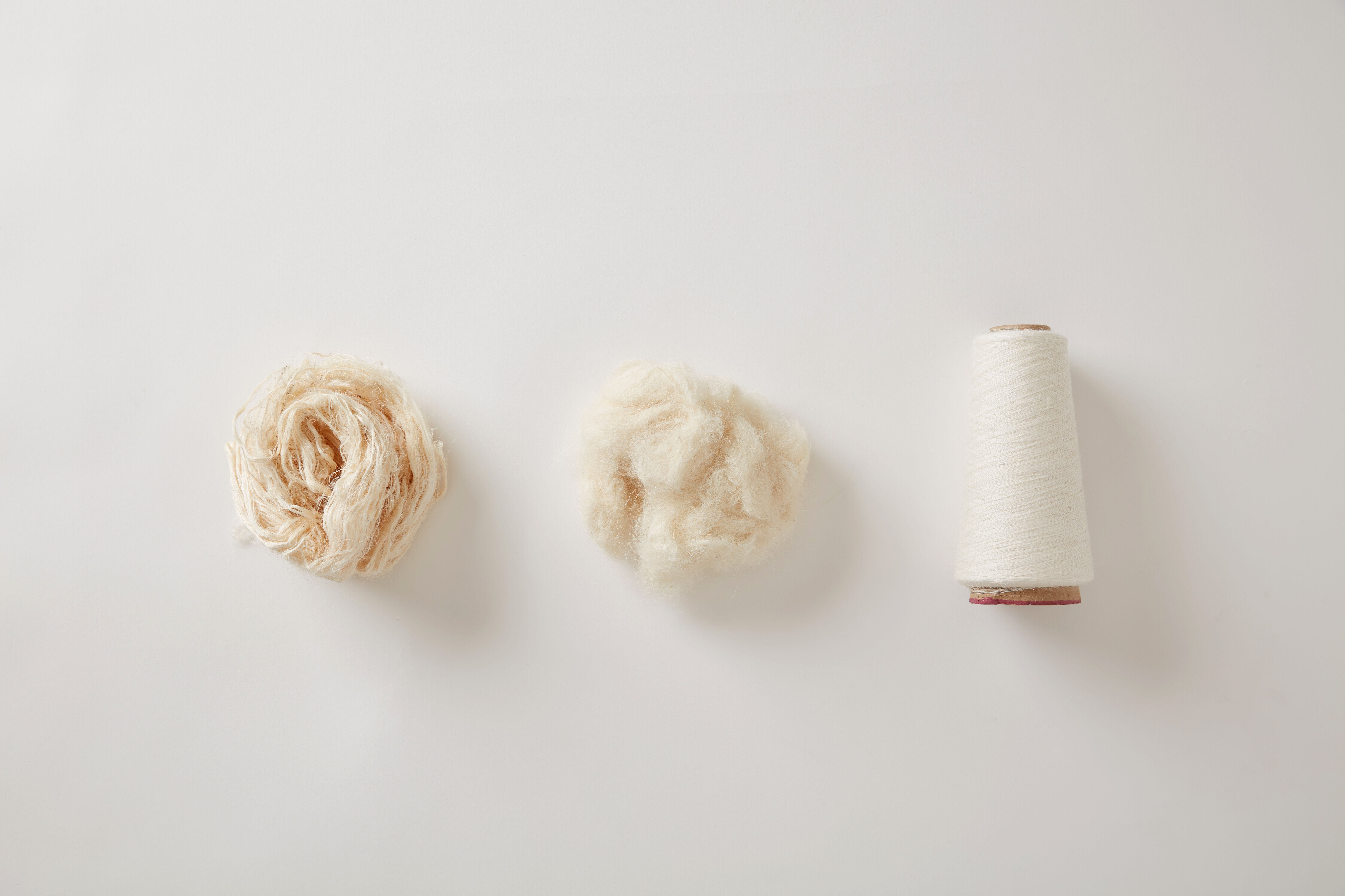 A spool of Piñayarn® on a bed of cream fabric A spool of Piñayarn® on a bed of cream fabric